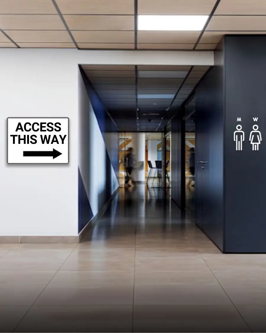 : Access this way directional arrow sign on an office wall pointing down a corridor next to restroom signs by Artista Sign and Design.